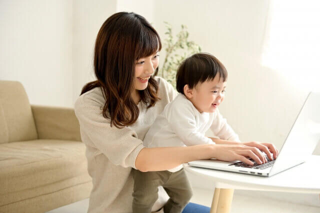 パソコンで作業するママと赤ちゃん